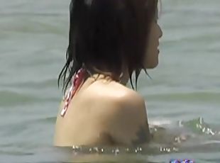 Asian babes relaxing on the beach get a boob sharking.